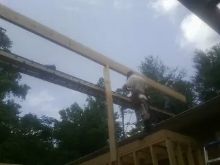 Carpenter setting a ridge beam over a new addition frame — Ice Dam Removal by Roofing Brothers in Nachusa