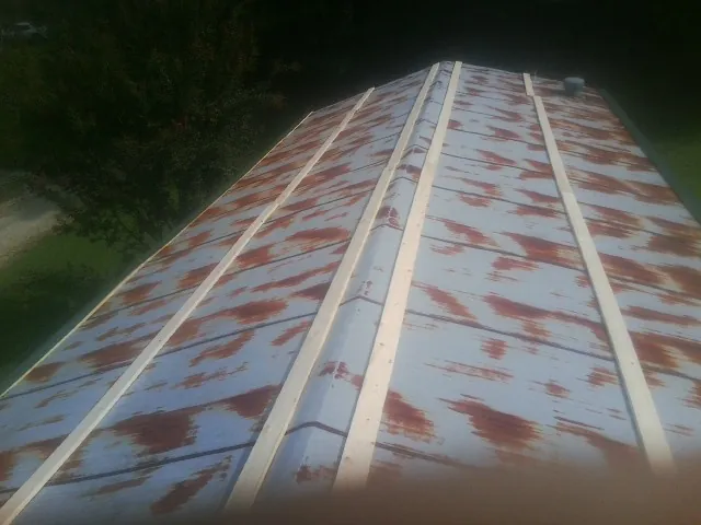 Rusted metal roof panels with new wood purlins before replacement — Storm Damage Roof Repair in Nachusa by Roofing Brothers