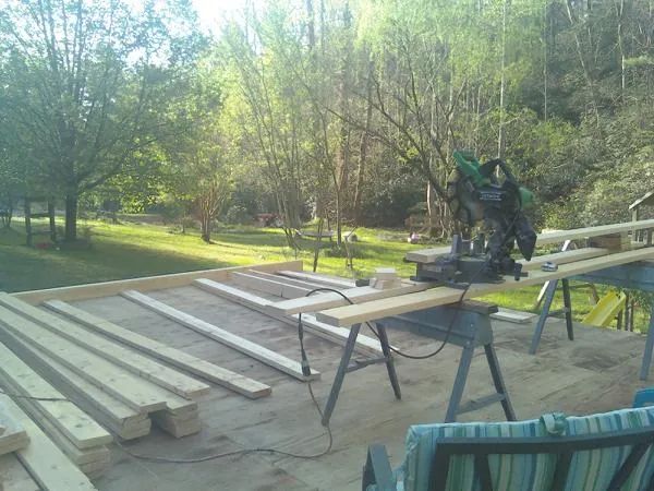 Miter saw and framing lumber on a deck under construction in Nachusa